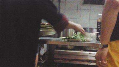 7月23日，漢麗軒烤肉超市昌平店，服務員將幾盤顧客剩菜（左手中疊在一起的是幾盤肉，其右手正整理韭菜）端回后廚，進行整理后準備再送往餐廳自助取餐區供顧客食用。